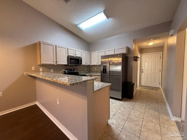 a kitchen with stainless steel appliances granite countertop a refrigerator stove and oven