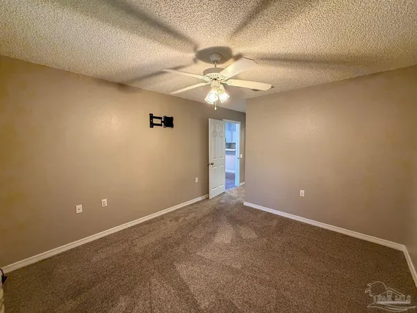 en empty room with windows and fan