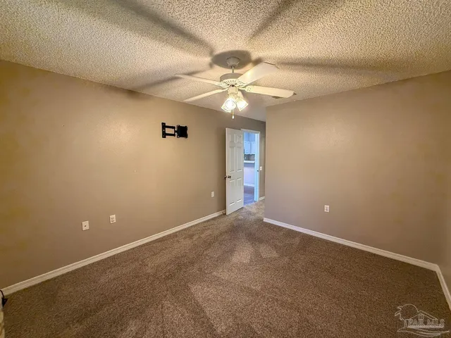 en empty room with windows and fan