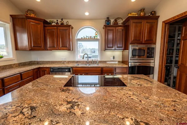 a kitchen with stainless steel appliances granite countertop a sink counter space cabinets and a window