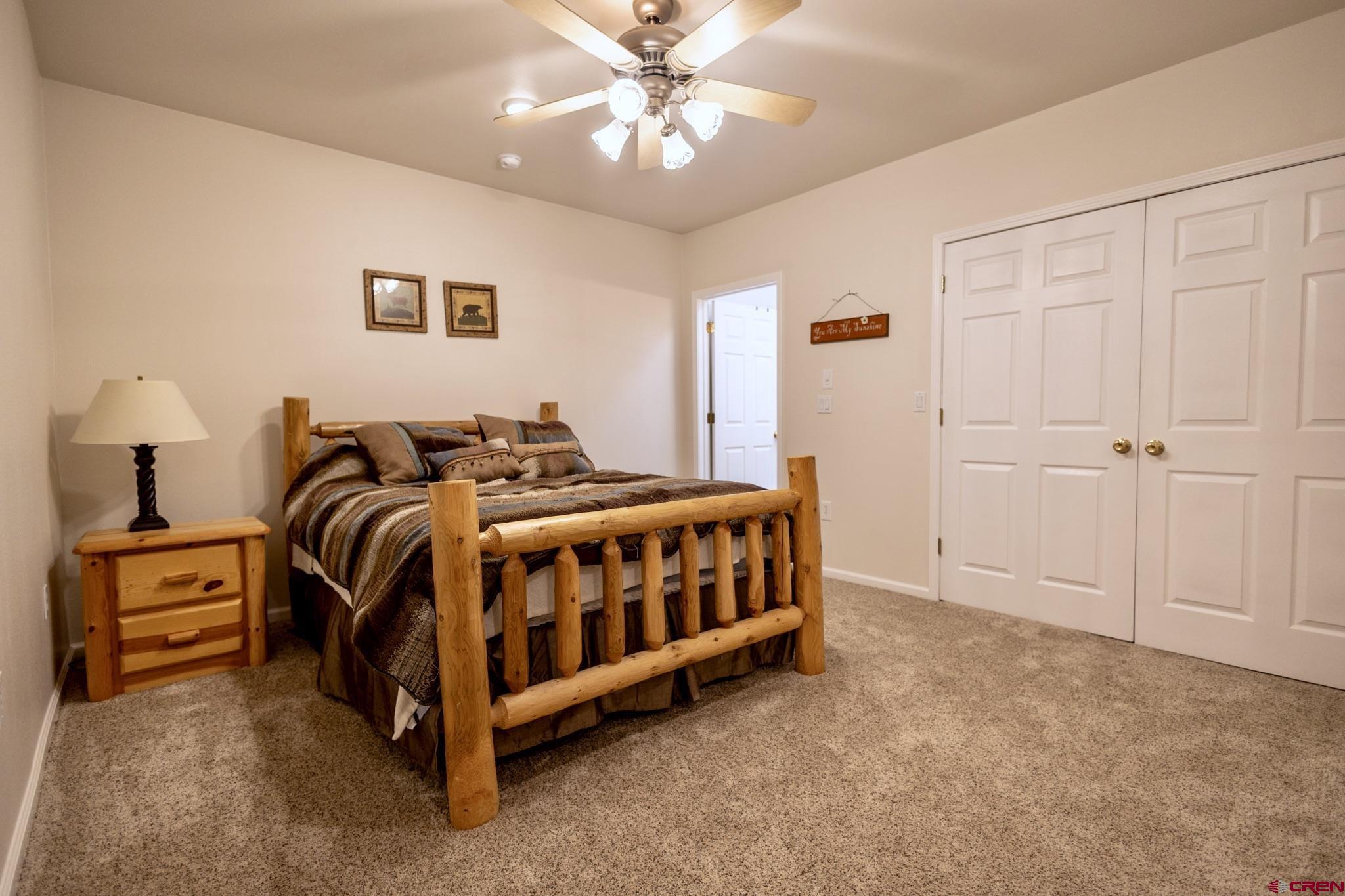 1253 3350th Road Crawford, CO 81415 - Photo 26 of 41 a bedroom with a bed and a chandelier