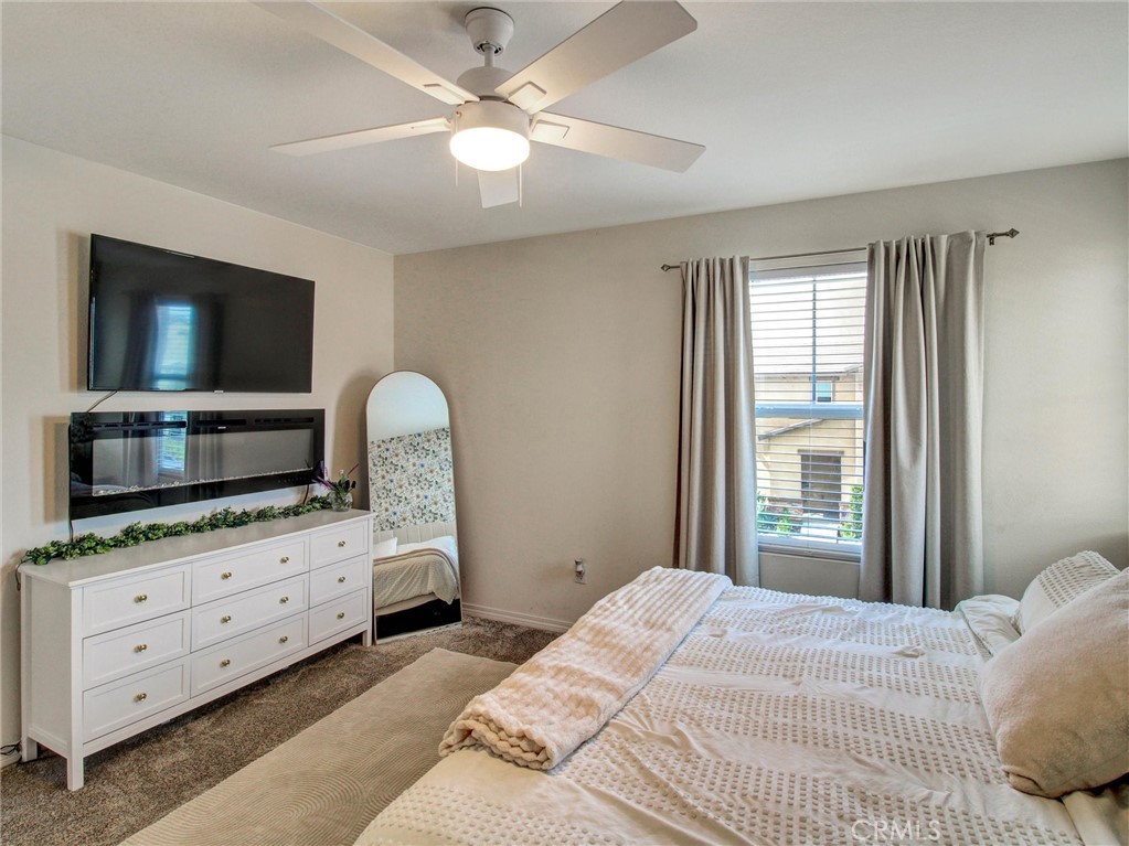 2497 Gunner Ridge Way Rialto, CA 92377 - Photo 20 of 49 a bedroom with a bed and a flat screen tv