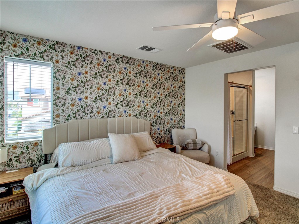 2497 Gunner Ridge Way Rialto, CA 92377 - Photo 21 of 49 a bedroom with a bed and a chandelier
