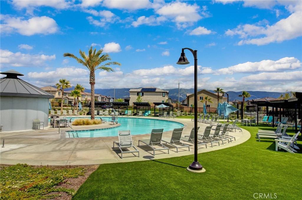 2497 Gunner Ridge Way Rialto, CA 92377 - Photo 47 of 49 a view of a swimming pool with a table and chairs