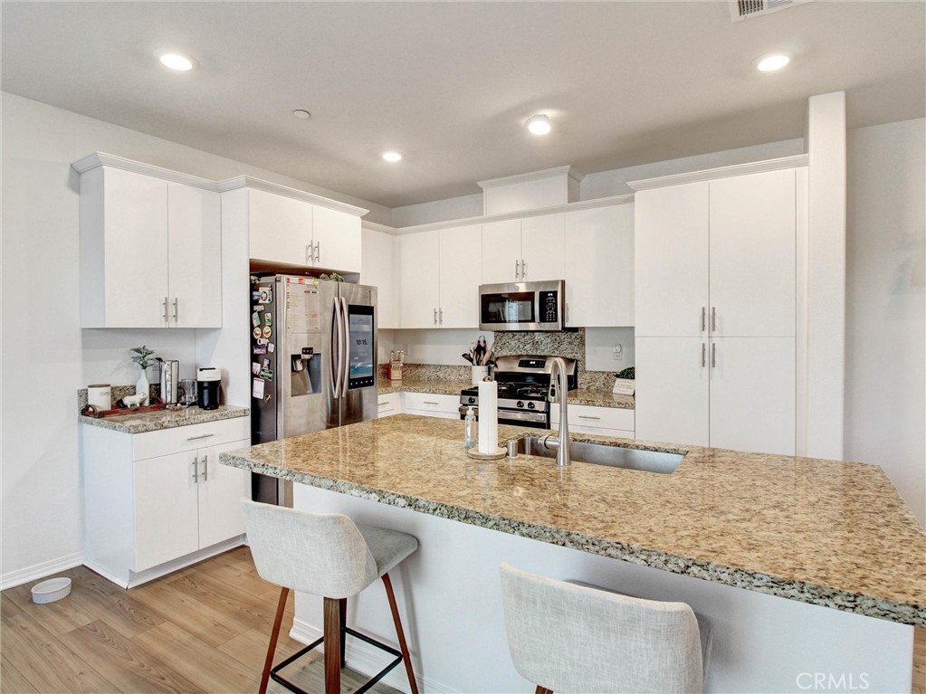 2497 Gunner Ridge Way Rialto, CA 92377 - Photo 5 of 49 a kitchen with stainless steel appliances granite countertop a sink refrigerator and microwave