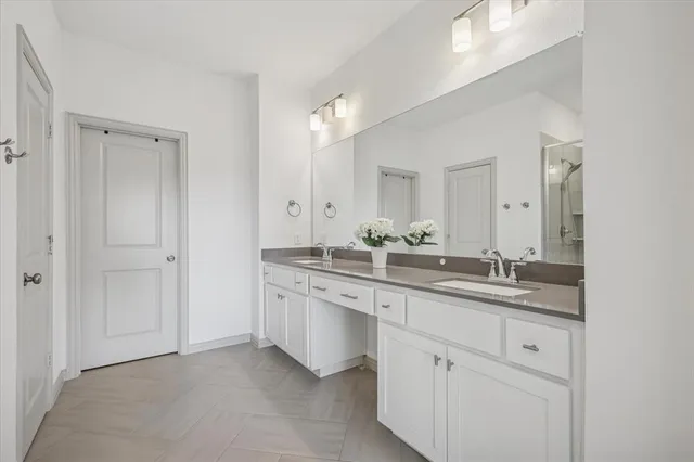 a bathroom with a granite countertop sink double and mirror
