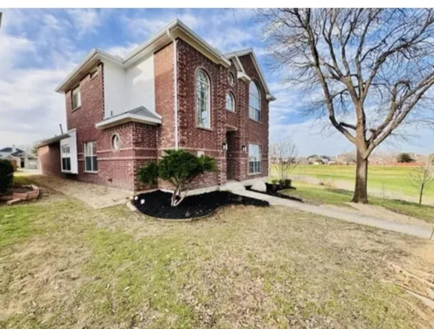 a view of a house with a yard and large trees