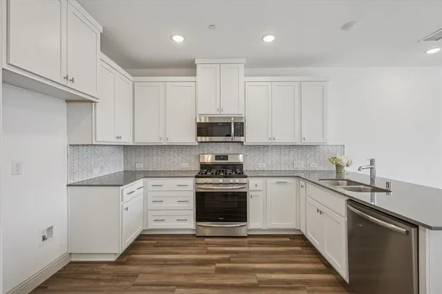 a kitchen with stainless steel appliances granite countertop a stove and a sink