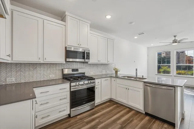 a kitchen with granite countertop white cabinets and white appliances