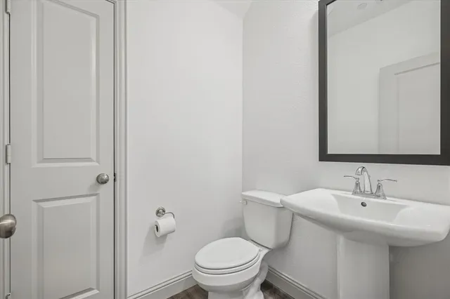 a bathroom with a sink a toilet and a mirror