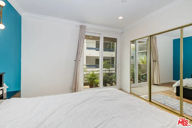 a bedroom with a bed and glass door