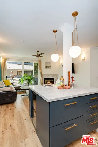 a kitchen with a sink dishwasher a stove a dining table and chairs with wooden floor