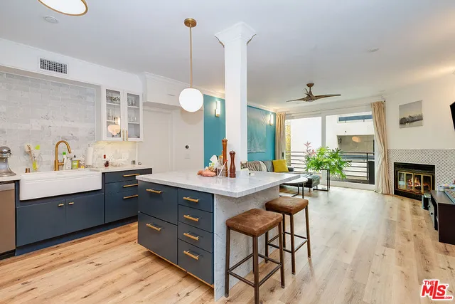 a kitchen with a sink appliances and a wooden floor