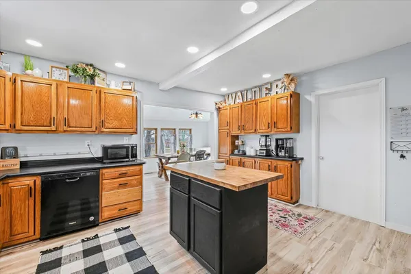 a kitchen with stainless steel appliances granite countertop a stove a sink dishwasher and a microwave oven with cabinets