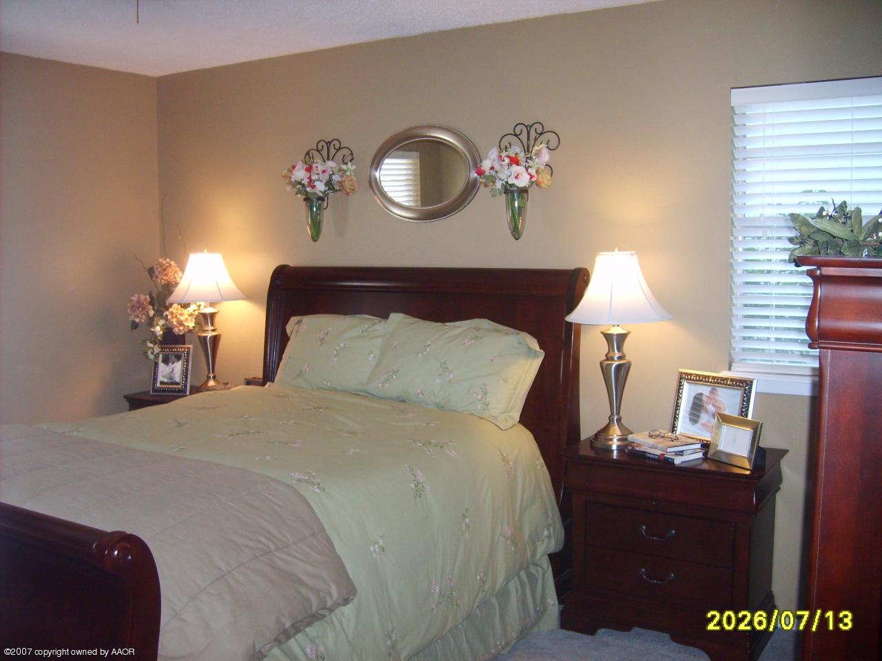 4405 Crockett Street Amarillo, TX 79110 - Photo 5 of 12 a bedroom with a bed and a potted plant
