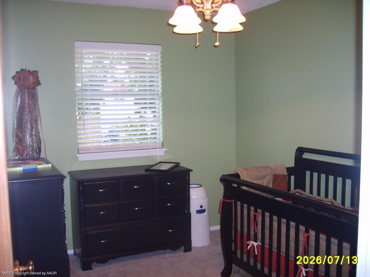 4405 Crockett Street Amarillo, TX 79110 - Photo 7 of 12 a bedroom with a bed and a chandelier