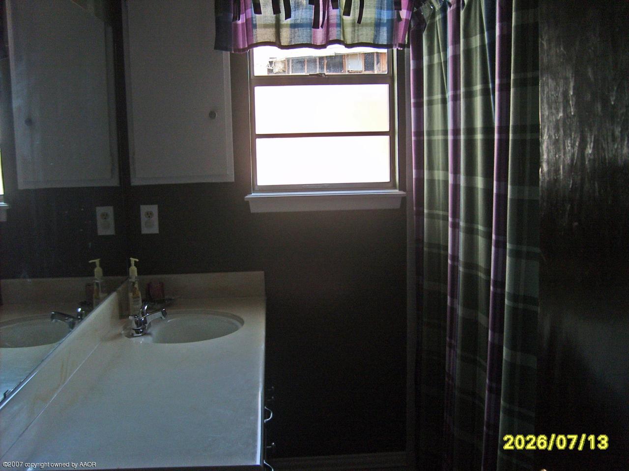 4405 Crockett Street Amarillo, TX 79110 - Photo 9 of 12 a bathroom with a sink and a window
