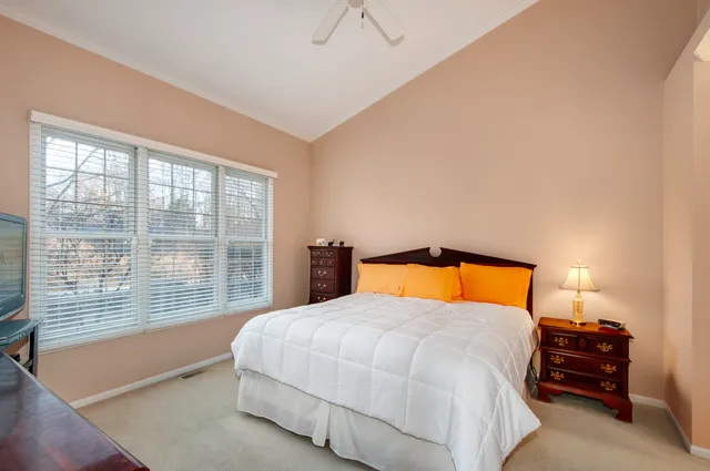 a bedroom with a bed and lamp next to a window