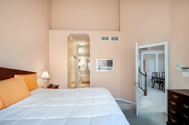 a bedroom with a bed and closet with chair