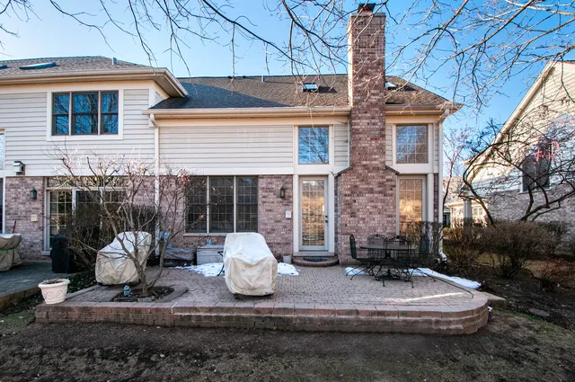 a view of a white house with couches chairs and a fire pit