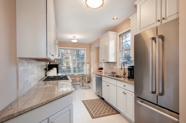 a kitchen with stainless steel appliances a sink a stove a refrigerator and cabinets