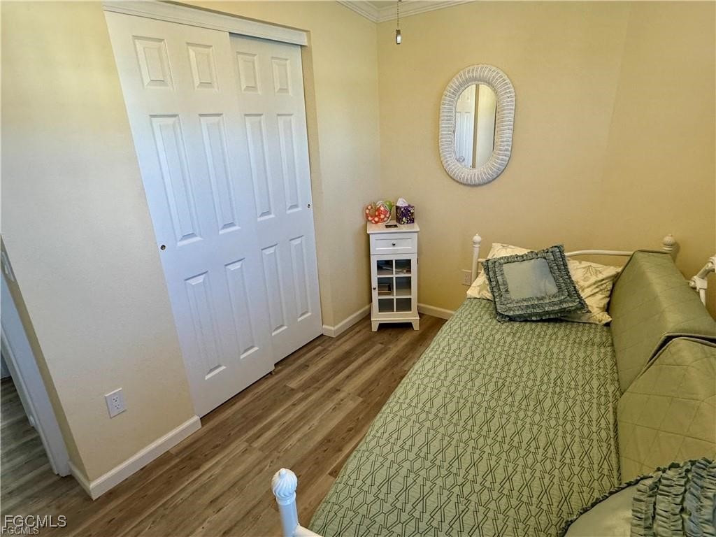 19681 Summerlin Road, Unit 217 Fort Myers, FL 33908 - Photo 17 of 24 a bedroom with a bed and wooden floor