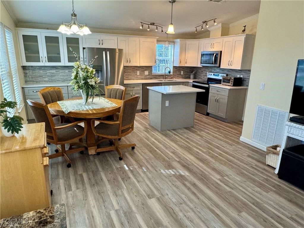 19681 Summerlin Road, Unit 217 Fort Myers, FL 33908 - Photo 7 of 24 a kitchen with kitchen island a dining table chairs stainless steel appliances and cabinets
