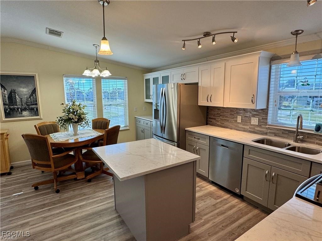 19681 Summerlin Road, Unit 217 Fort Myers, FL 33908 - Photo 10 of 24 a kitchen with stainless steel appliances granite countertop a kitchen island hardwood floor sink stove dining table and chairs