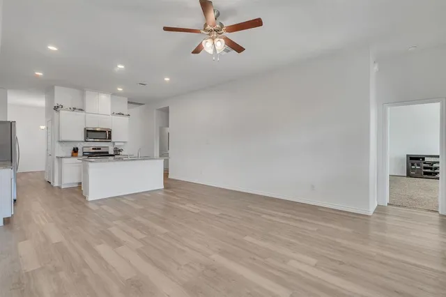 a view of kitchen with granite countertop cabinets and refrigerator