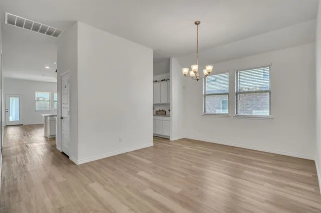 a view of a room with wooden floor staircase and a kitchen