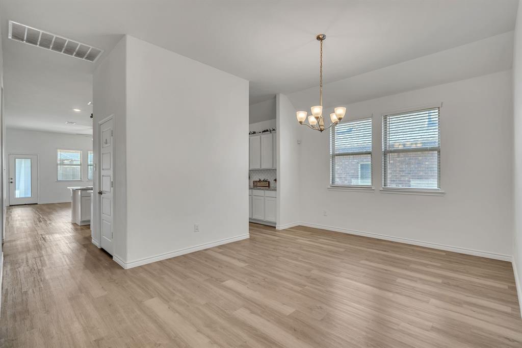 1009 Azure Lane Celina, TX 75009 - Photo 8 of 20 a view of a room with wooden floor staircase and a kitchen