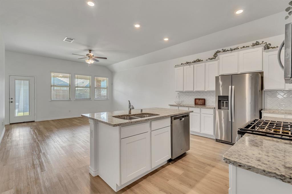 1009 Azure Lane Celina, TX 75009 - Photo 9 of 20 a kitchen with stainless steel appliances granite countertop a sink stove and refrigerator