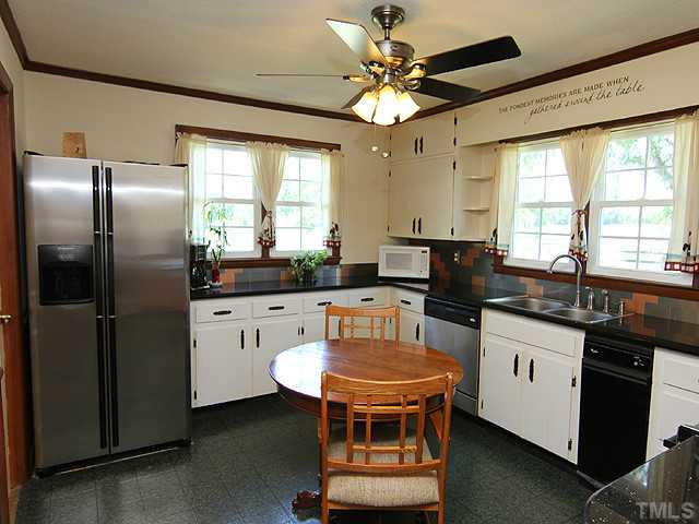 1948 Johnston County Road Benson, NC 27504 - Photo 5 of 13 a kitchen with stainless steel appliances granite countertop a stove a refrigerator a sink a stove and white cabinets
