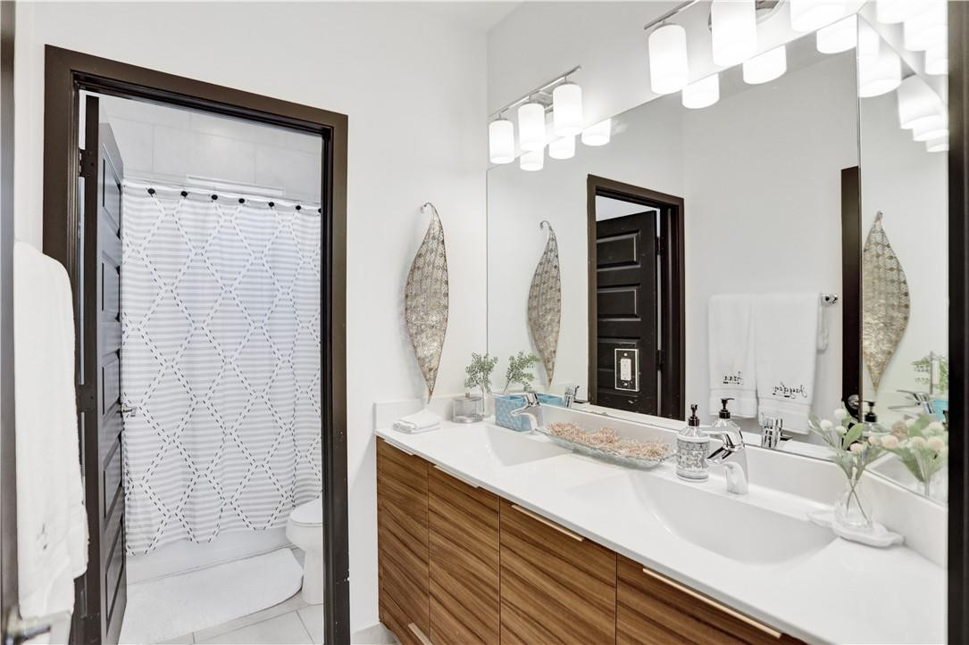 16001 Southwest 136 Way Miami, FL 33196 - Photo 45 of 66 a bathroom with a double vanity sink a mirror and a shower