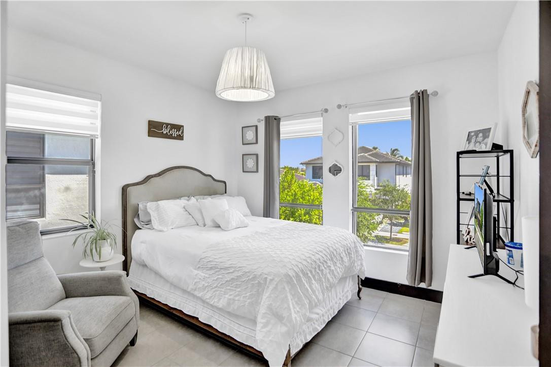 16001 Southwest 136 Way Miami, FL 33196 - Photo 49 of 66 a bedroom with a bed lamps and a large mirror on the dresser