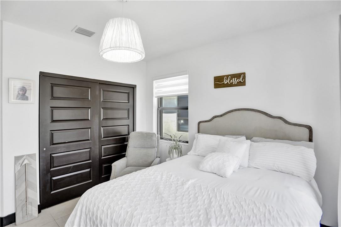 16001 Southwest 136 Way Miami, FL 33196 - Photo 50 of 66 a bedroom with a bed and a chandelier