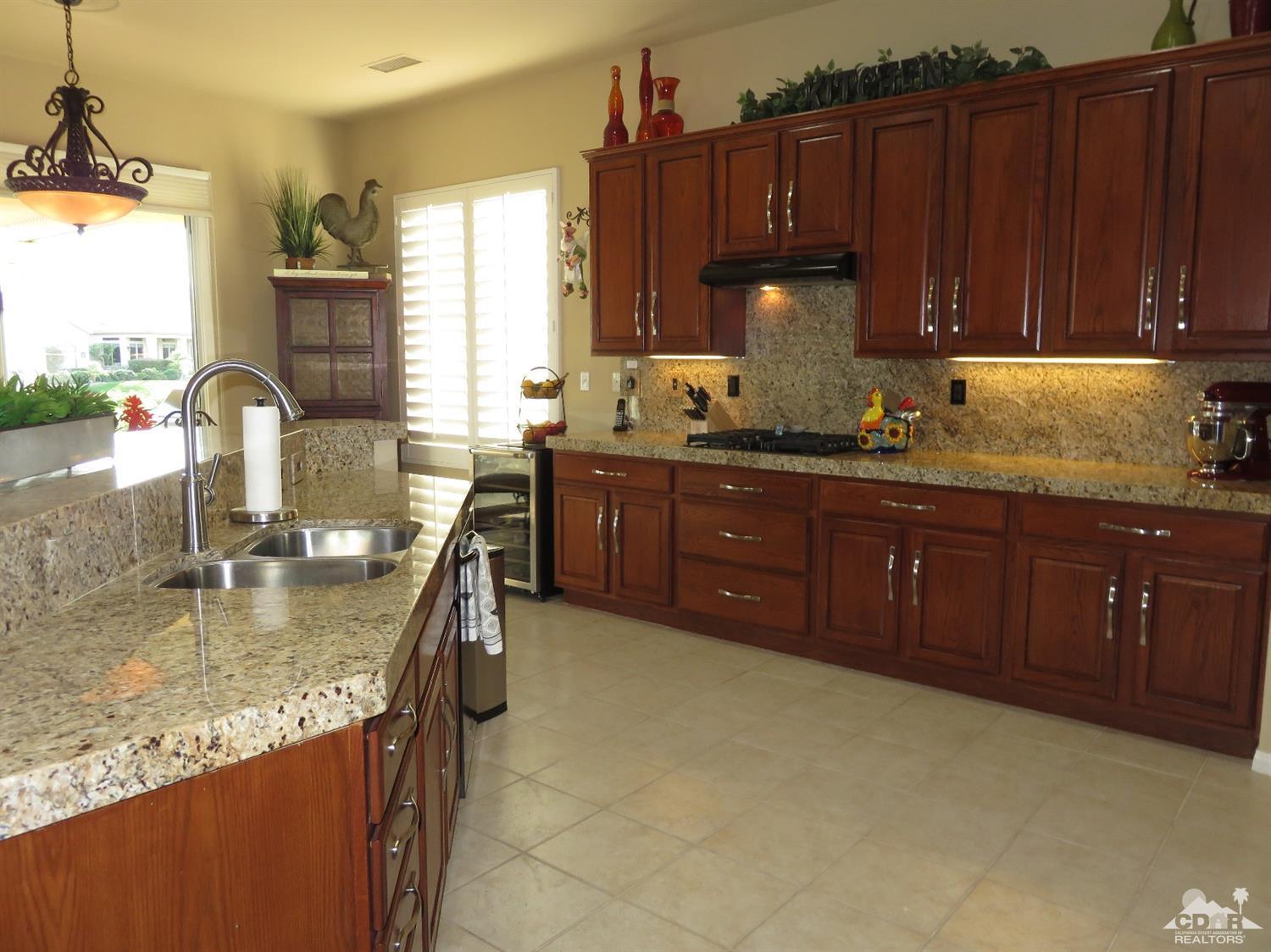 80567 Knightswood Road Indio, CA 92201 - Photo 3 of 57 a kitchen with stainless steel appliances granite countertop a sink a stove and a wooden cabinets