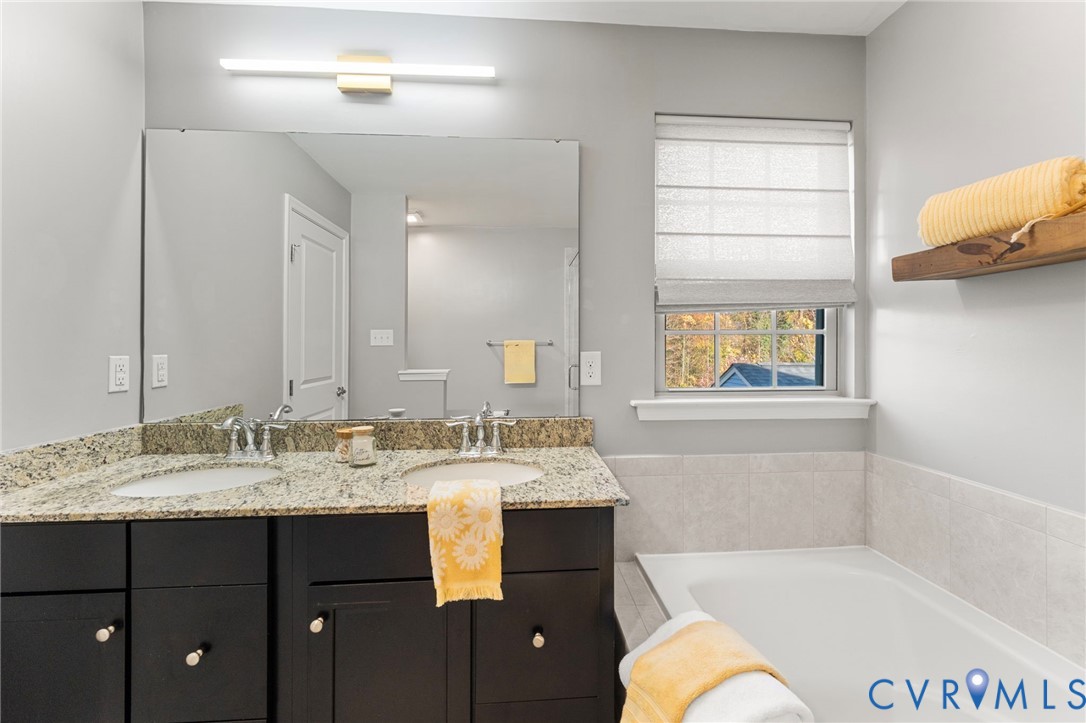 5504 Riverside Heights Way Richmond, VA 23225 - Photo 18 of 29 a bathroom with a tub sink and mirror