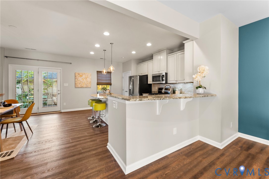 5504 Riverside Heights Way Richmond, VA 23225 - Photo 6 of 29 a kitchen with stainless steel appliances a refrigerator and a dining table