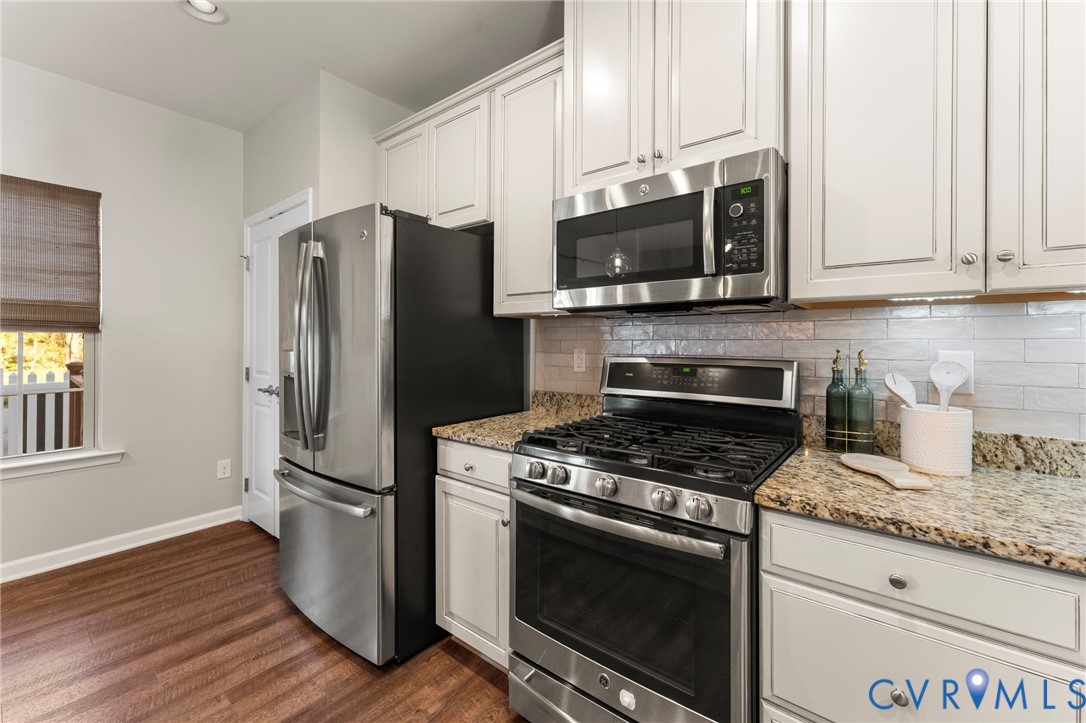 5504 Riverside Heights Way Richmond, VA 23225 - Photo 9 of 29 a kitchen with stainless steel appliances granite countertop a stove a refrigerator and a microwave