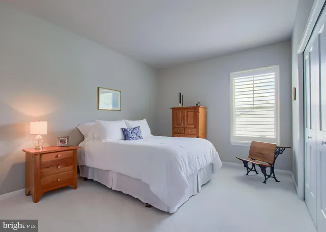 a bedroom with a bed chair and a window