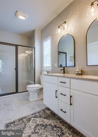 a bathroom with a double vanity sink mirror and toilet