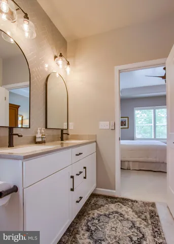 a bathroom with a double vanity sink and a window