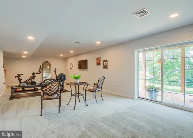 a view of a big room with lounge chair windows and ceiling fan