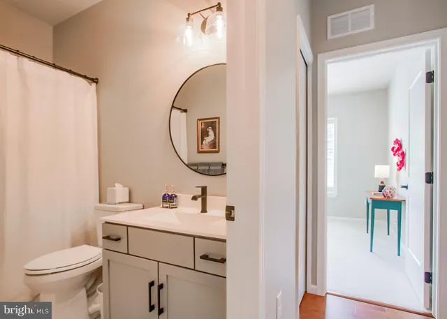 a bathroom with a sink vanity mirror and toilet