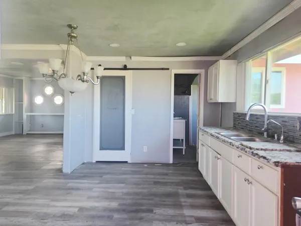 a kitchen with a sink cabinets and wooden floor