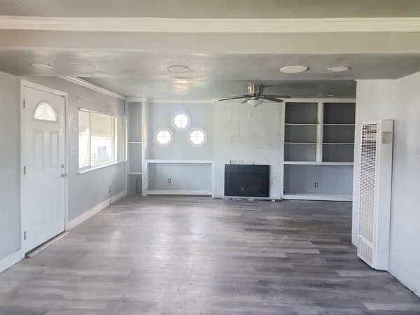 a view of an empty room with a fireplace and a window