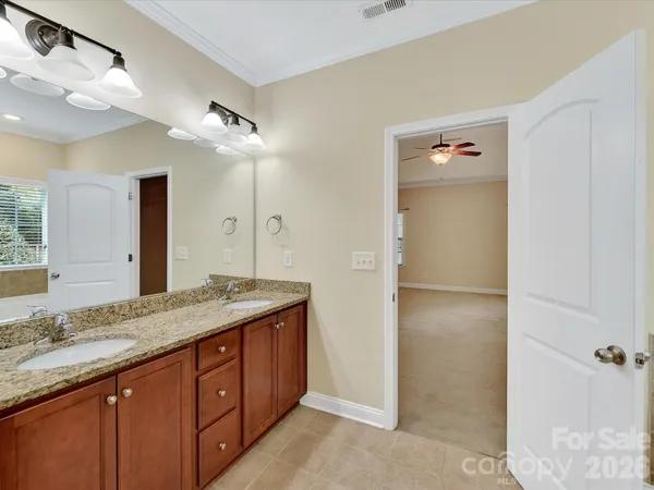 a spacious bathroom with a granite countertop sink a mirror and a shower