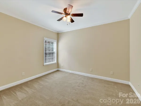 an empty room with a window and a ceiling fan