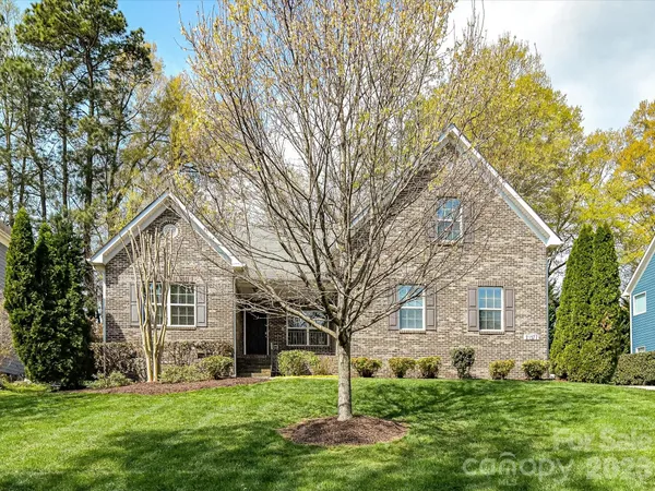 a front view of a house with a yard and trees